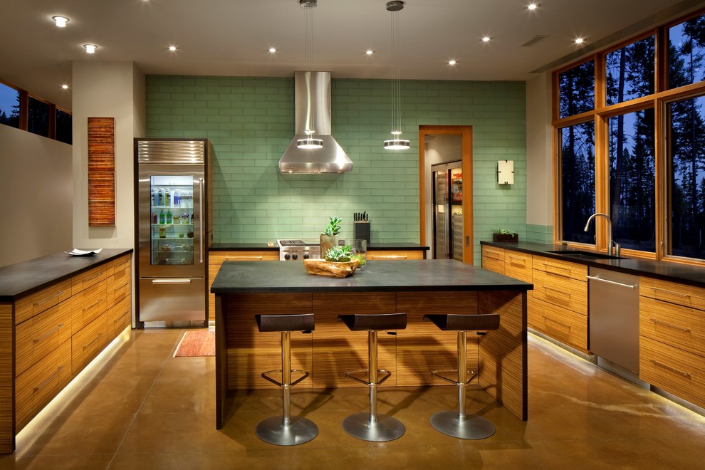 Example of a transitional concrete floor kitchen design with light wood cabinets, stainless steel appliances and an island