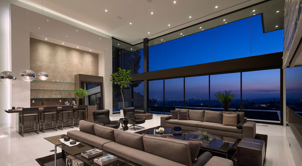 Expansive contemporary living room in Los Angeles with a home bar, grey walls and a wall-mounted tv.