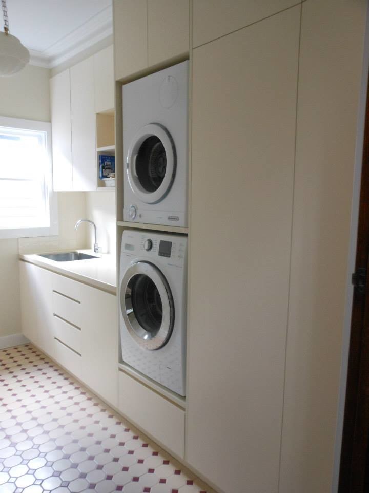 Laundry room - modern laundry room idea in Melbourne with flat-panel cabinets and a stacked washer/dryer