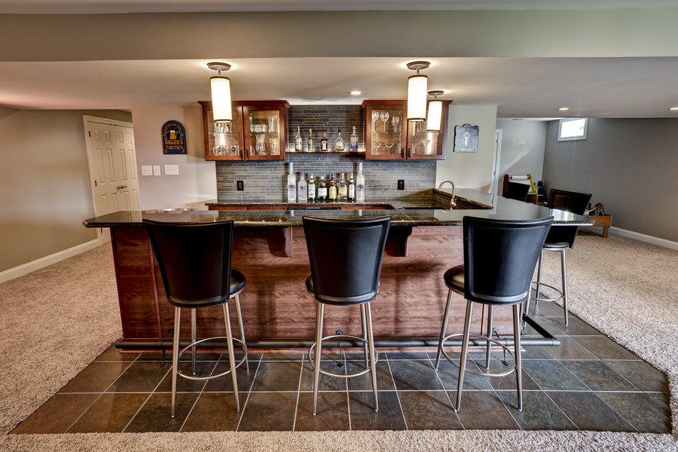 Large transitional u-shaped home bar in Philadelphia with dark wood cabinets, grey splashback, brown floor, matchstick tile splashback and carpet.