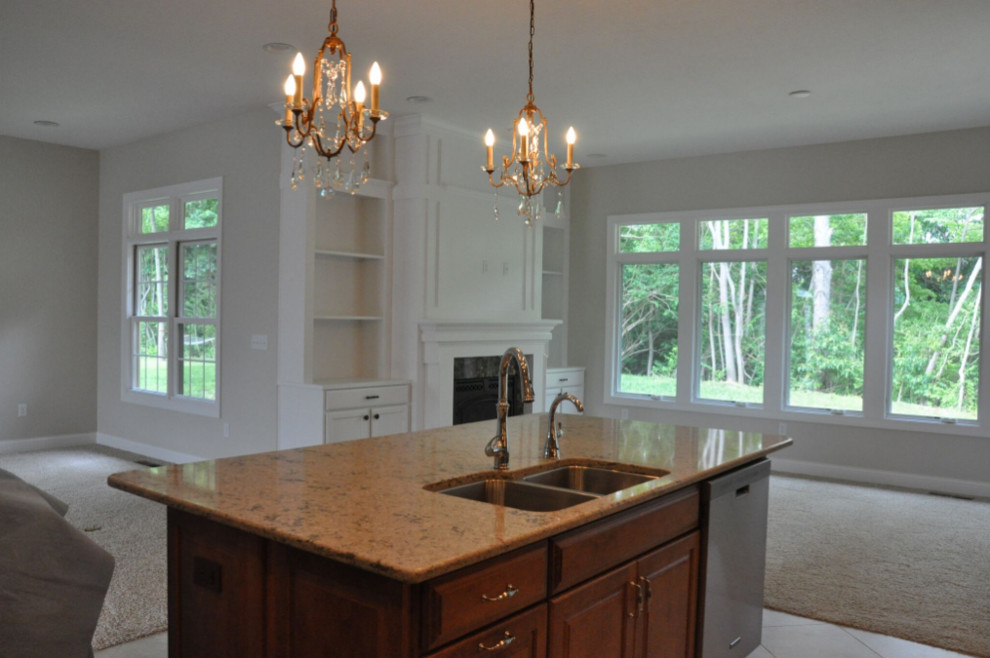 Example of a mid-sized classic porcelain tile and beige floor open concept kitchen design with a double-bowl sink, raised-panel cabinets, brown cabinets and an island