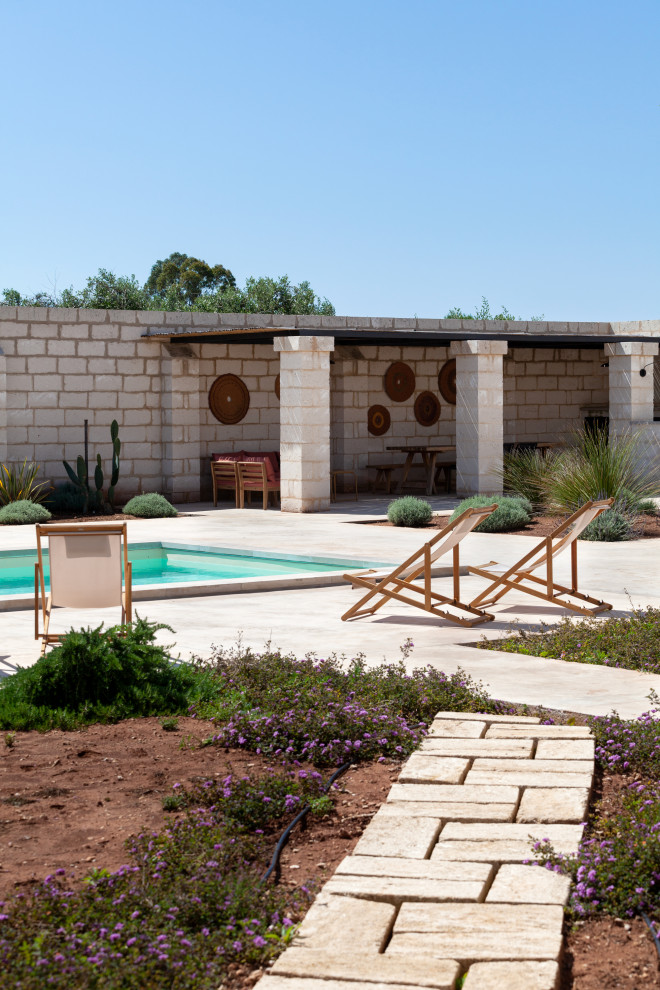 Exemple d'un piscine avec aménagement paysager méditerranéen rectangle avec une cour et des pavés en béton.