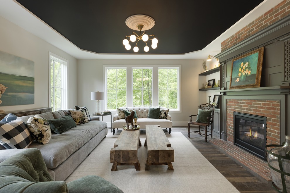 Photo of a traditional formal enclosed living room in Minneapolis with white walls, dark hardwood floors, a standard fireplace, brown floor and a brick fireplace surround.