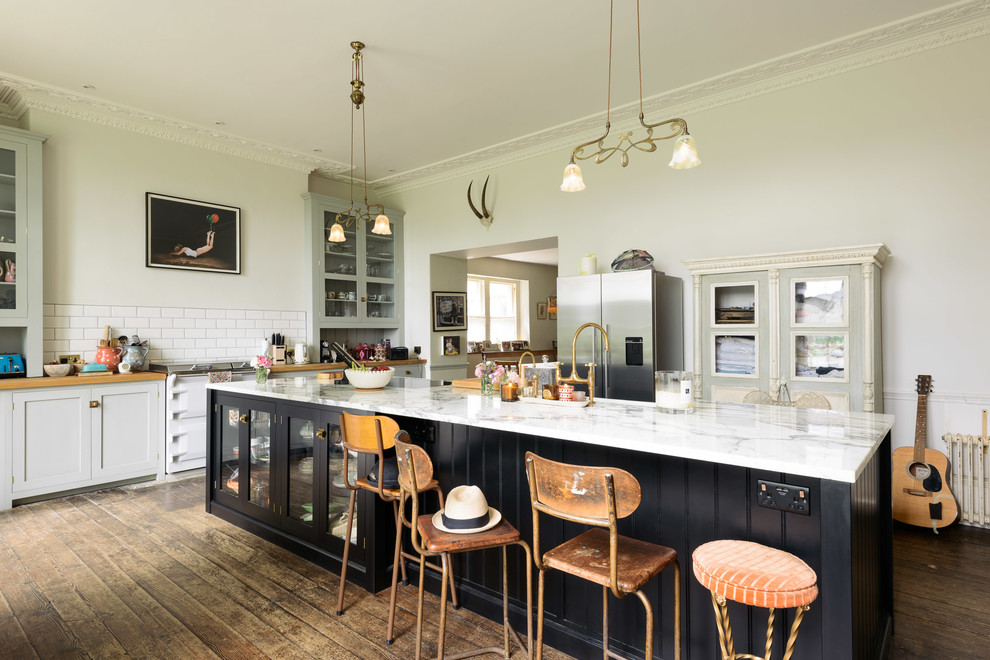 Inspiration for a large eclectic single-wall separate kitchen in Other with shaker cabinets, grey cabinets, marble benchtops, white splashback, subway tile splashback, white appliances, medium hardwood floors, a peninsula and brown floor.