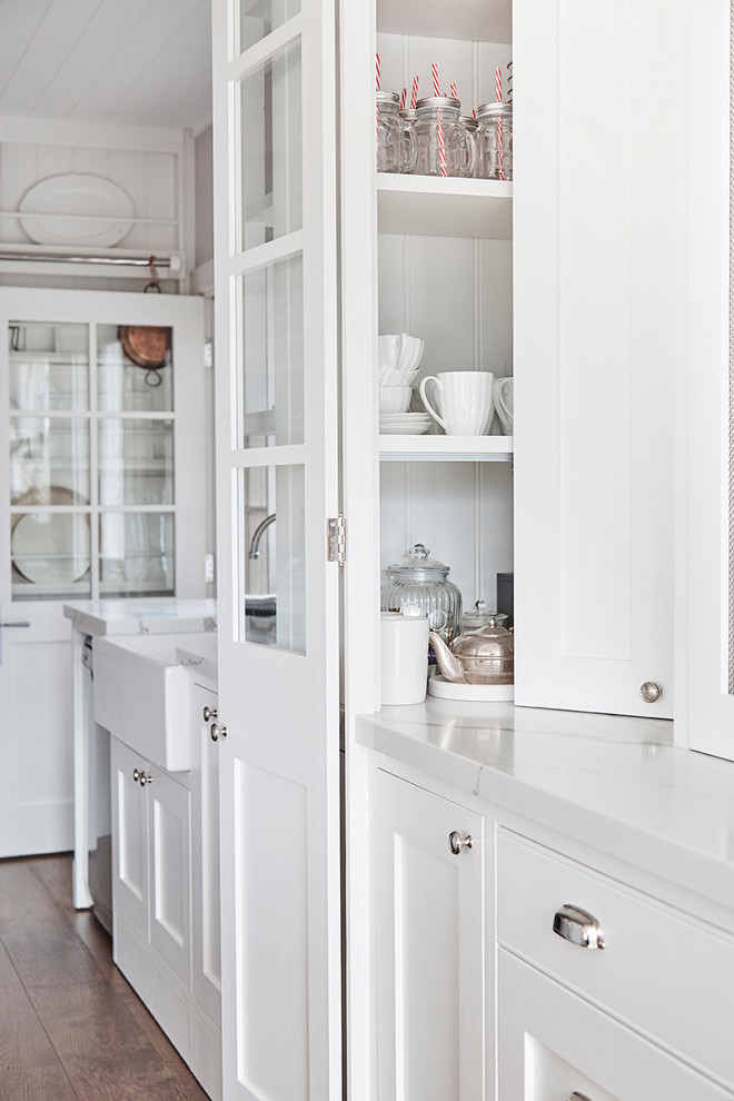 Design ideas for a mid-sized country u-shaped kitchen pantry in Sydney with a farmhouse sink, shaker cabinets, white cabinets, marble benchtops, white splashback, subway tile splashback, stainless steel appliances, light hardwood floors and with island.