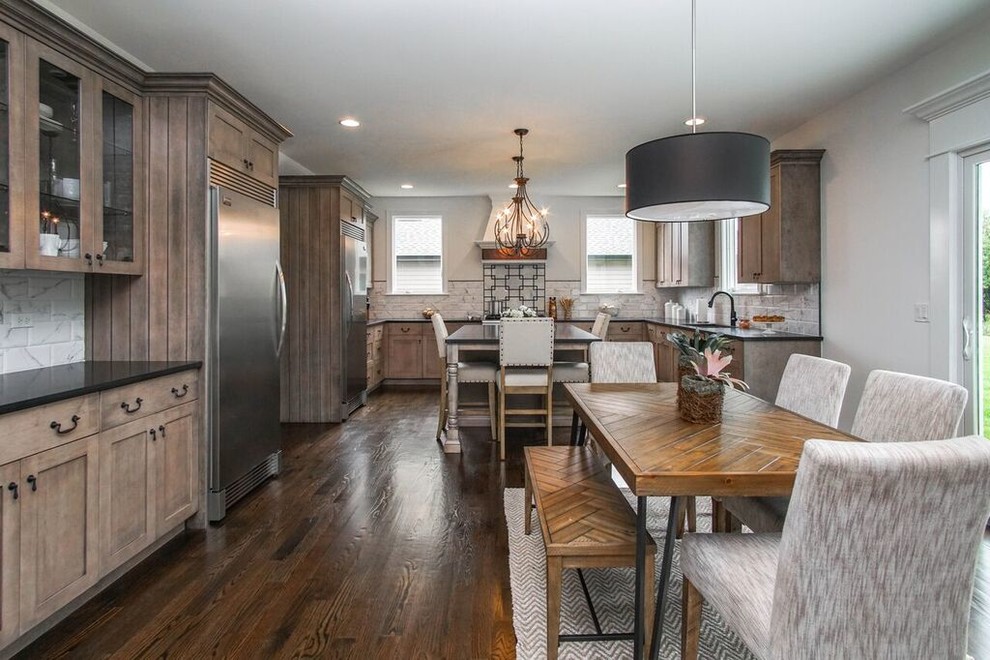 Inspiration for a transitional u-shaped dark wood floor and black floor eat-in kitchen remodel in Chicago with an undermount sink, shaker cabinets, granite countertops, white backsplash, ceramic backsplash, stainless steel appliances, an island and black countertops