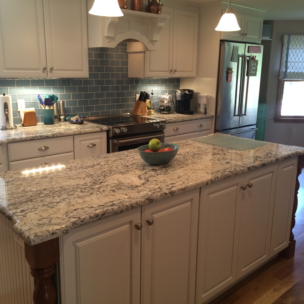 Eat-in kitchen - transitional u-shaped medium tone wood floor eat-in kitchen idea in Boston with an undermount sink, raised-panel cabinets, white cabinets, granite countertops, blue backsplash, glass tile backsplash, stainless steel appliances and an island