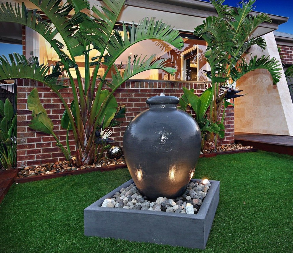 Photo of a mid-sized contemporary front yard formal garden in Melbourne with a water feature.