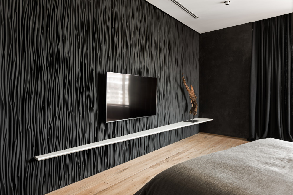 Immagine di una camera degli ospiti industriale di medie dimensioni con pareti nere, pavimento in legno massello medio, pavimento marrone, boiserie e TV