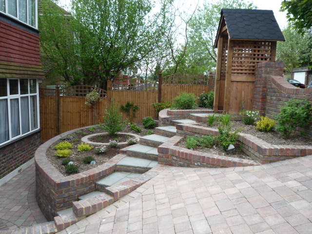 This is an example of a small traditional front fully shaded garden for summer in Surrey with a garden path and concrete paving.
