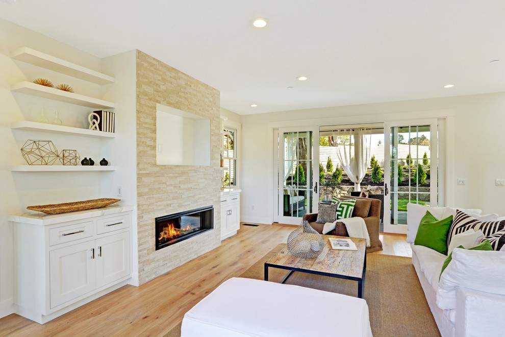 Photo of a large country living room in San Francisco with white walls, light hardwood floors, a standard fireplace, a built-in media wall and a stone fireplace surround.