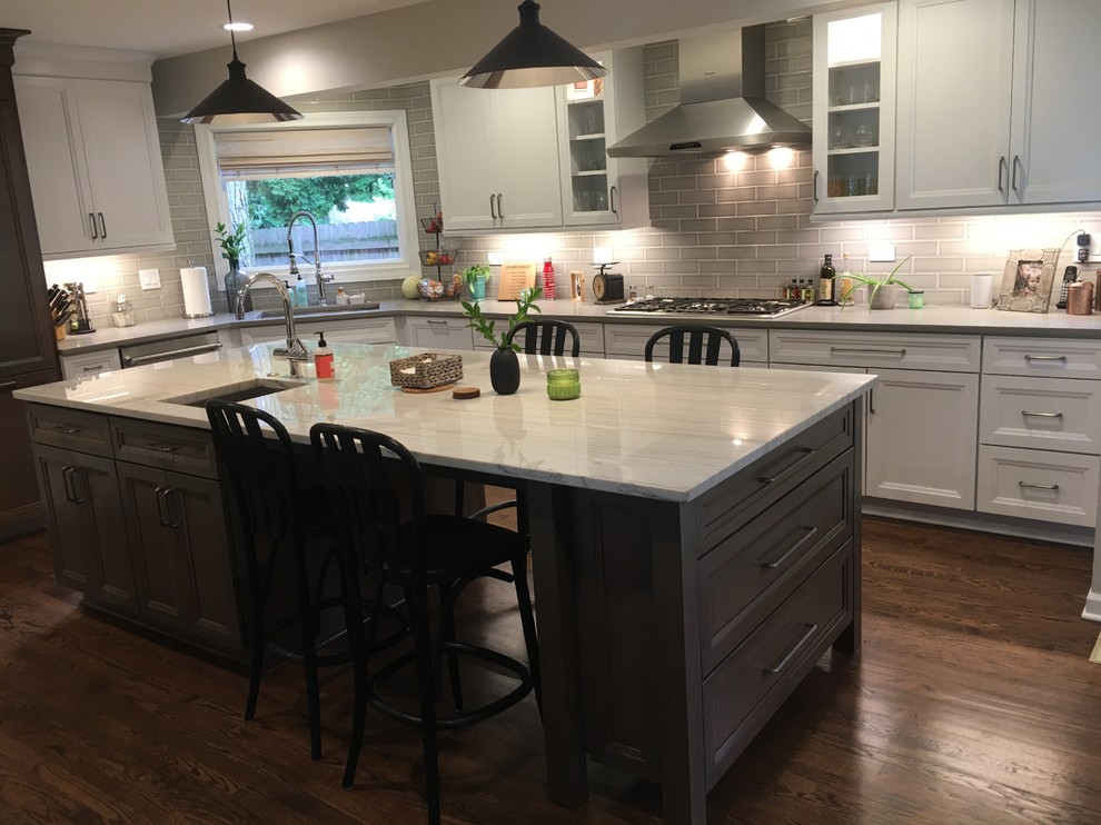 Design ideas for a large transitional u-shaped open plan kitchen in Chicago with an undermount sink, flat-panel cabinets, white cabinets, quartz benchtops, grey splashback, ceramic splashback, stainless steel appliances, dark hardwood floors, with island, brown floor and grey benchtop.