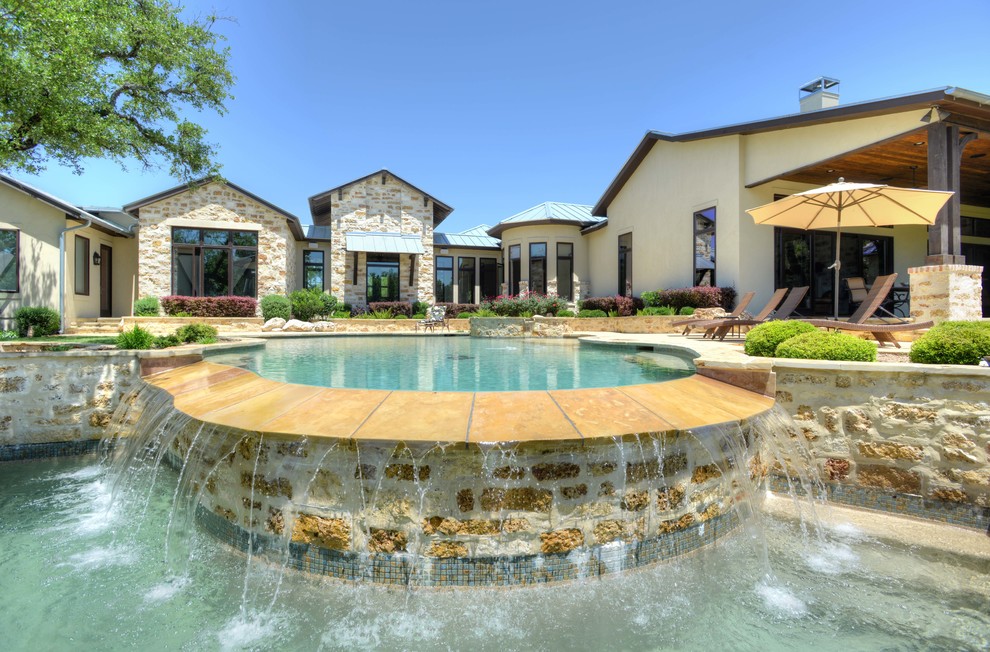 Pool - large rustic backyard stone and custom-shaped infinity pool idea in Austin