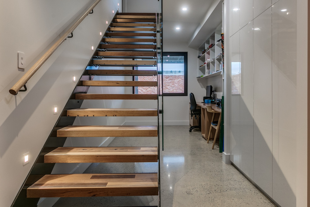 Design ideas for a mid-sized industrial floating staircase in Adelaide with glass railing.