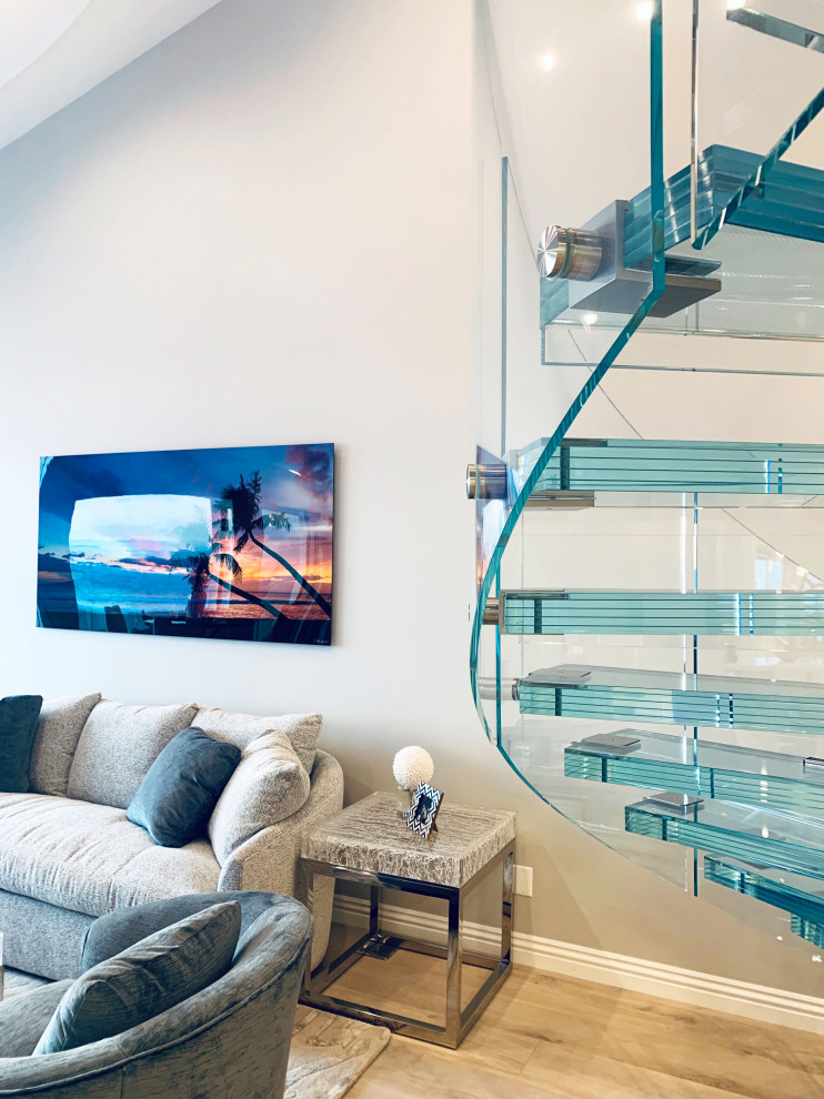 Design ideas for a mid-sized modern glass spiral staircase in Los Angeles with glass risers and glass railing.