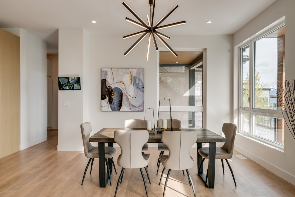 Design ideas for a mid-sized contemporary dining room in Vancouver with white walls, laminate floors and brown floor.