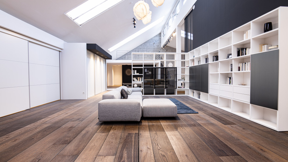 Стильный дизайн: гостиная комната в современном стиле с темным паркетным полом и серым полом - последний тренд