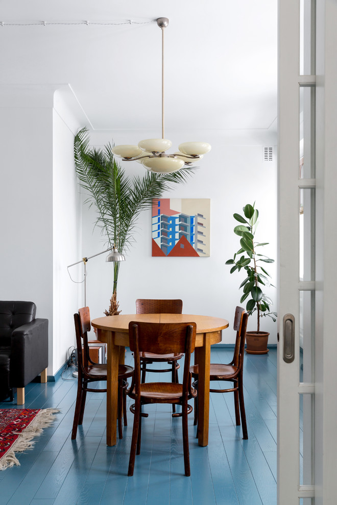 Пример оригинального дизайна: гостиная комната в стиле ретро с белыми стенами, деревянным полом и синим полом