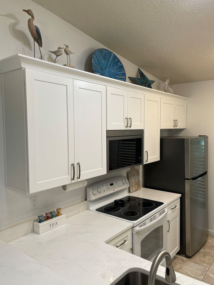 Photo of a small transitional u-shaped eat-in kitchen in Tampa with shaker cabinets, white cabinets and quartz benchtops.