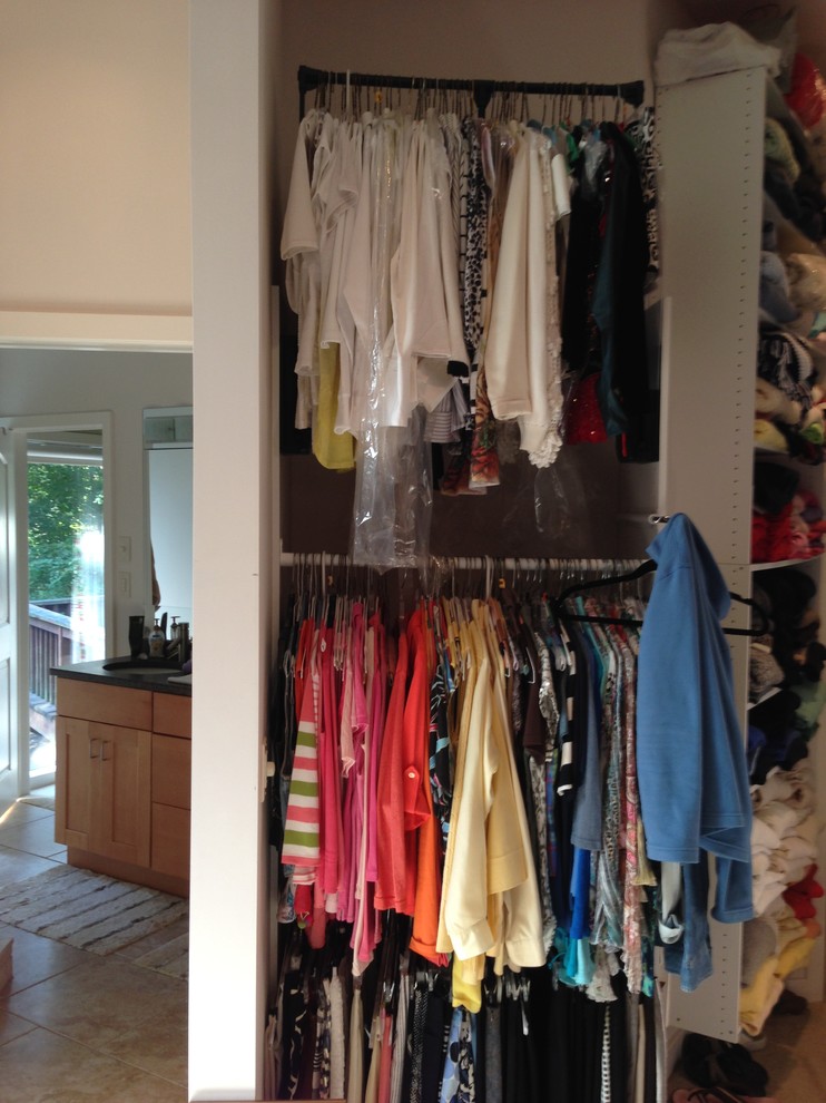 This is an example of a large transitional women's walk-in wardrobe in Philadelphia with white cabinets and carpet.