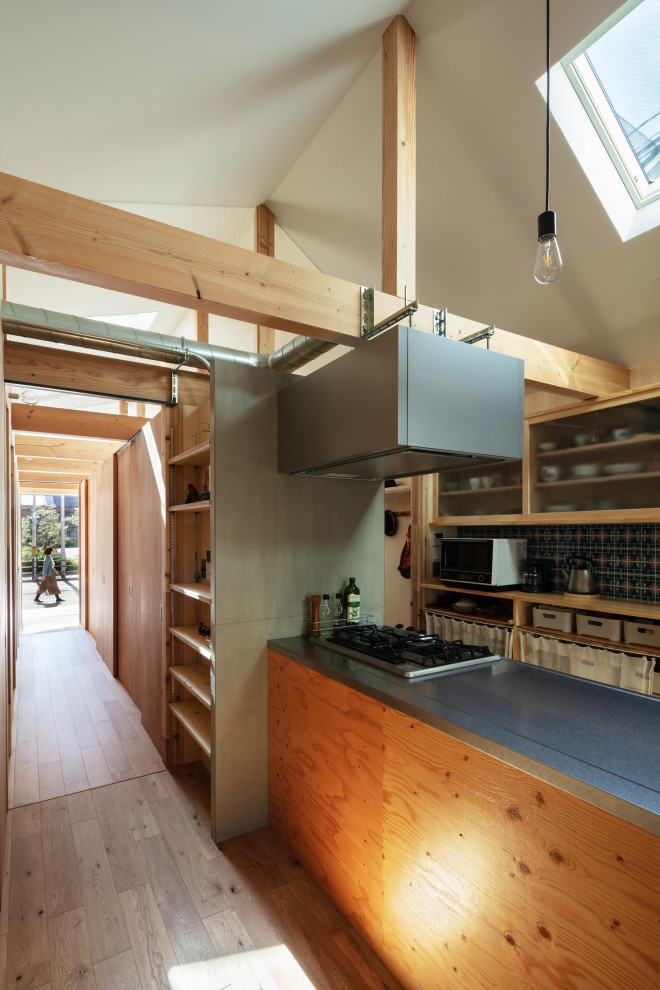 Inspiration for a small industrial galley kitchen/diner in Osaka with a submerged sink, glass-front cabinets, medium wood cabinets, stainless steel worktops, grey splashback, ceramic splashback, stainless steel appliances, plywood flooring, an island, brown floors, brown worktops and a drop ceiling.