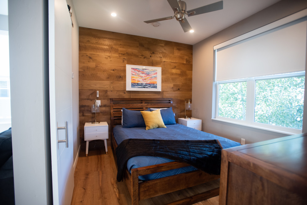 Design ideas for a small modern guest bedroom in Denver with grey walls and light hardwood floors.