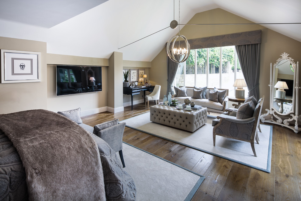 Expansive country master bedroom in Oxfordshire with beige walls and dark hardwood floors.