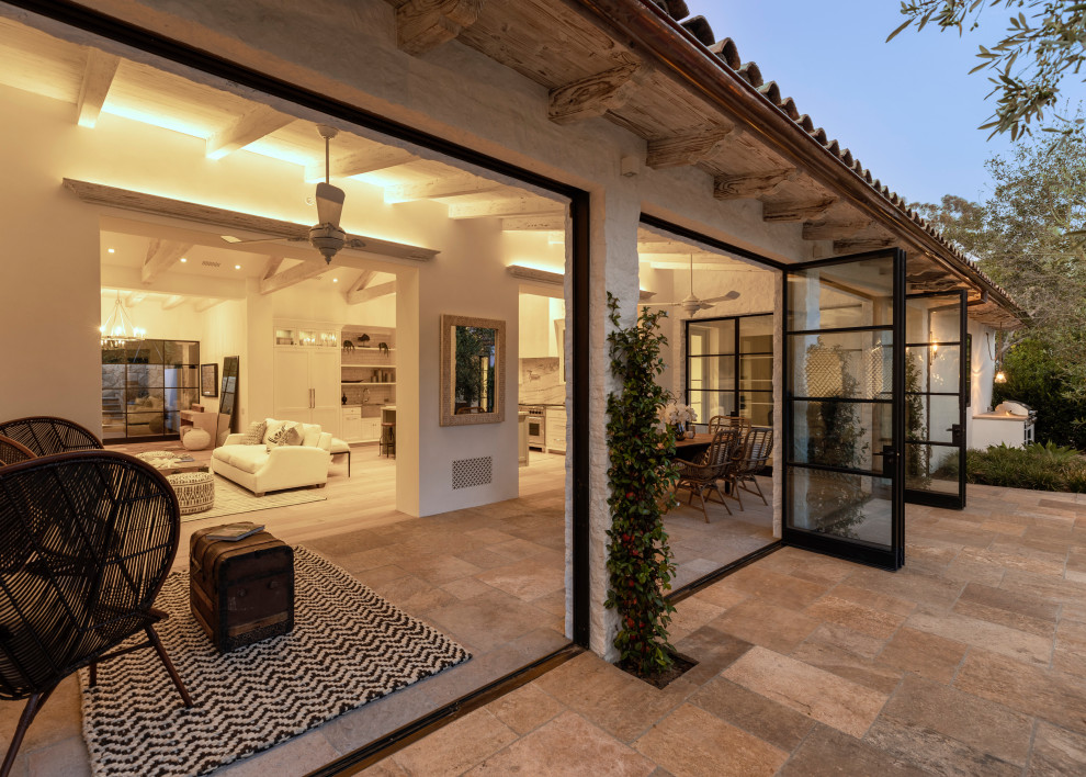 Photo of a mediterranean patio in Santa Barbara with tile and a roof extension.
