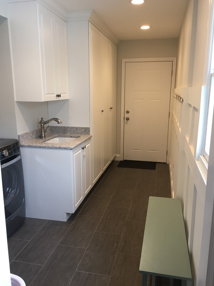 Mid-sized traditional galley utility room in New York with an undermount sink, raised-panel cabinets, white cabinets, granite benchtops, white walls, slate floors and a side-by-side washer and dryer.
