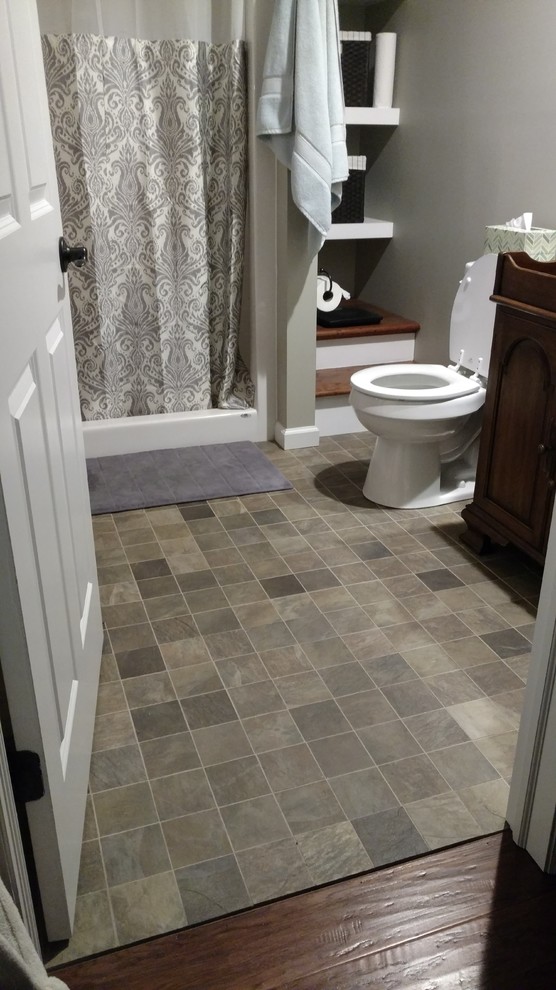 Example of a mid-sized eclectic master multicolored tile and porcelain tile porcelain tile alcove shower design with furniture-like cabinets, medium tone wood cabinets, a two-piece toilet, gray walls and a drop-in sink