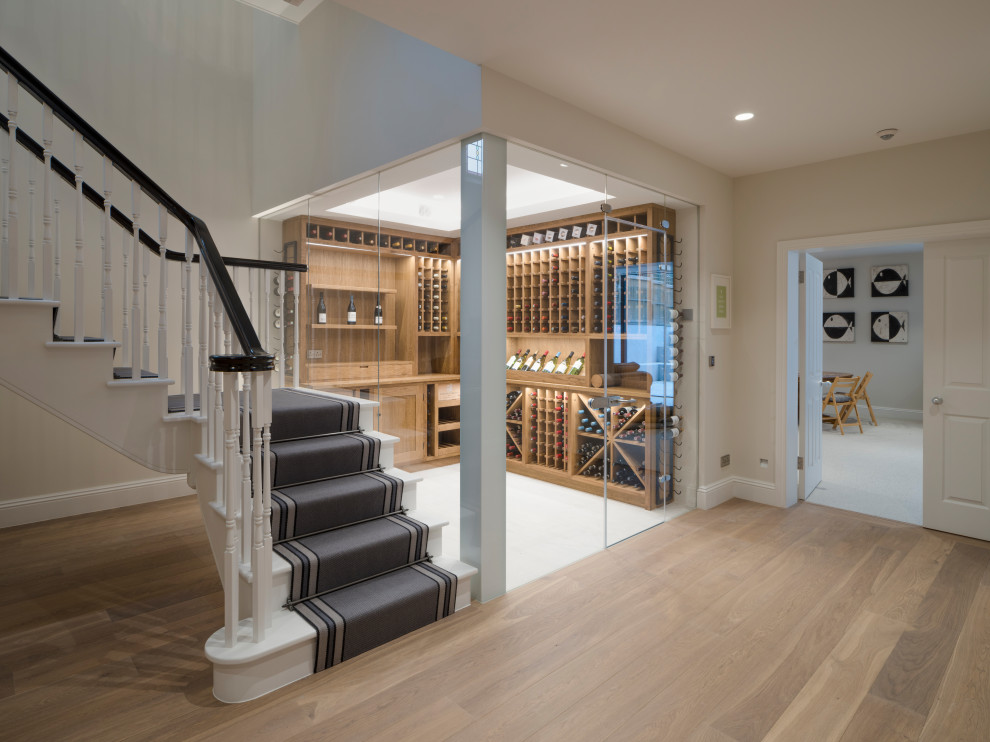 Inspiration for a classic wine cellar in London with light hardwood flooring and display racks.
