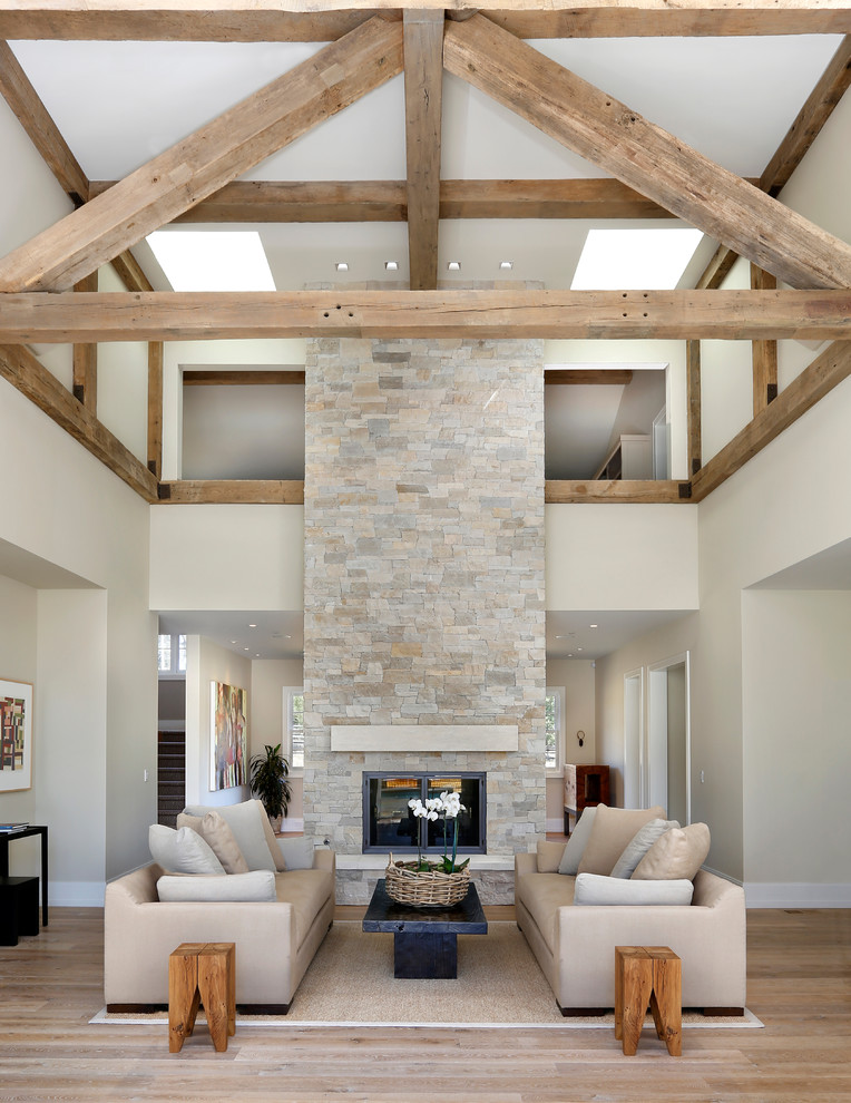 This is an example of a country formal open concept living room in San Francisco with a two-sided fireplace and a stone fireplace surround.