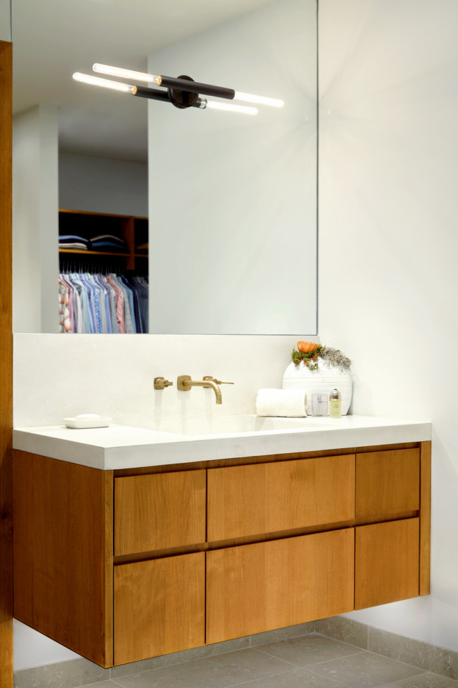 Example of a large trendy master beige tile marble floor, gray floor and double-sink bathroom design in Other with flat-panel cabinets, medium tone wood cabinets, an undermount tub, a one-piece toilet, white walls, an integrated sink, quartz countertops, white countertops and a floating vanity