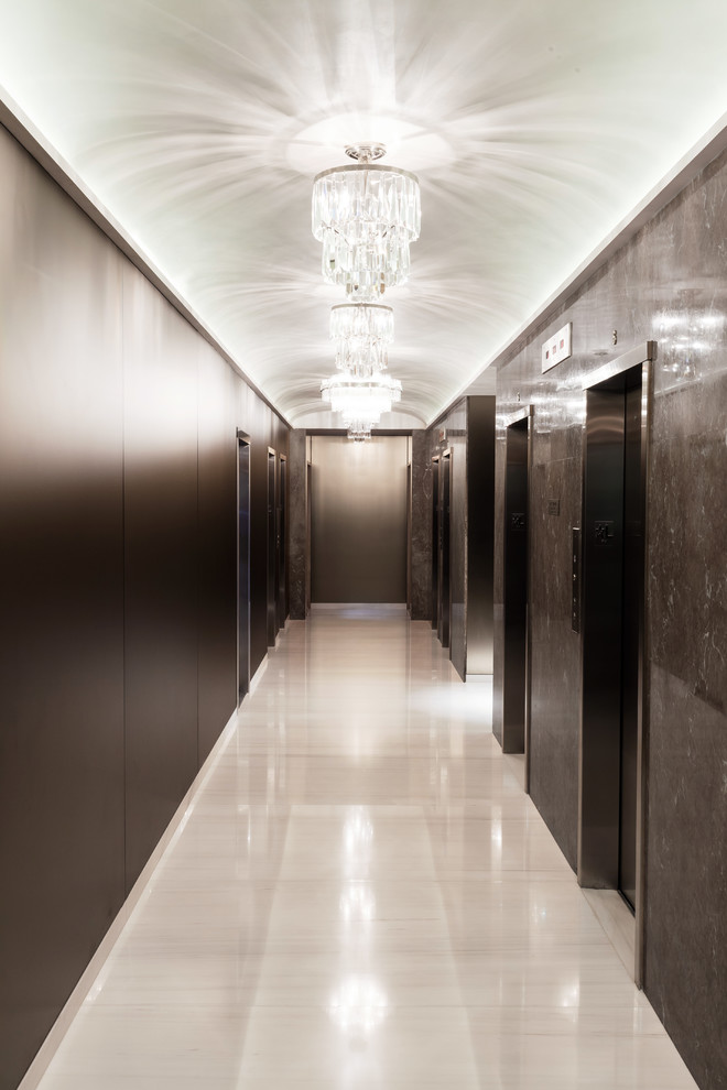 Photo of a large transitional hallway in New York with marble floors and white floor.