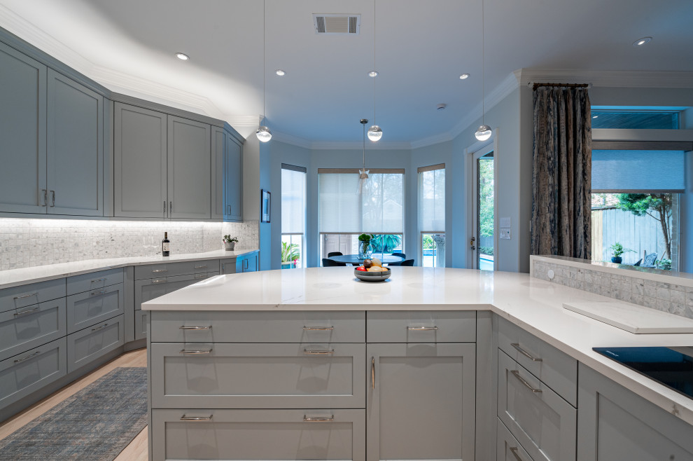 Large transitional u-shaped light wood floor and beige floor eat-in kitchen photo in Houston with an undermount sink, shaker cabinets, gray cabinets, quartz countertops, ceramic backsplash, stainless steel appliances and white countertops