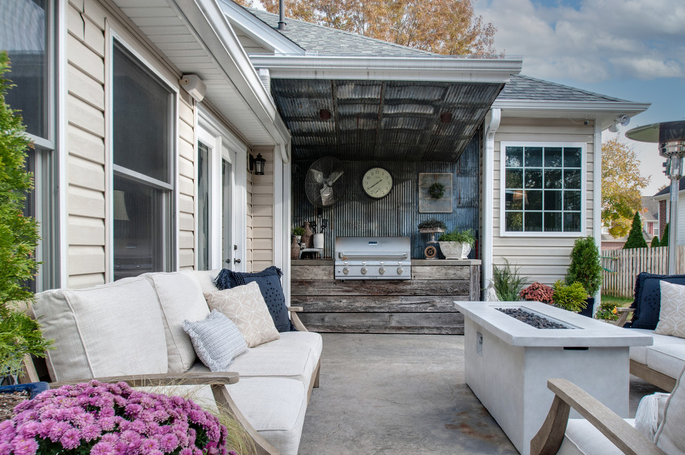 Réalisation d'une petite terrasse arrière champêtre avec une cuisine d'été, du béton estampé et une extension de toiture.