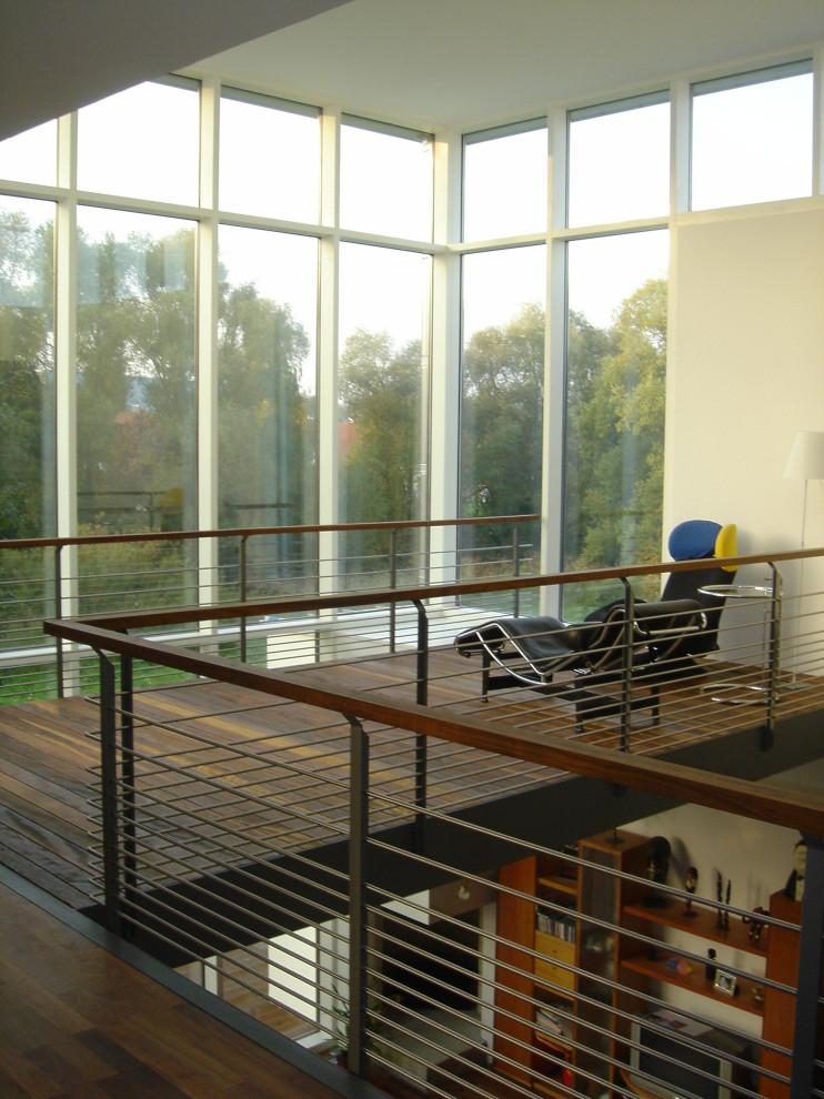 Geräumiger Moderner Wintergarten mit dunklem Holzboden, normaler Decke und braunem Boden in Sonstige