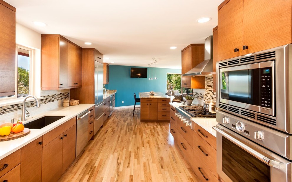 Large transitional galley eat-in kitchen in Seattle with an undermount sink, flat-panel cabinets, medium wood cabinets, quartzite benchtops, brown splashback, matchstick tile splashback, stainless steel appliances, light hardwood floors, with island and brown floor.