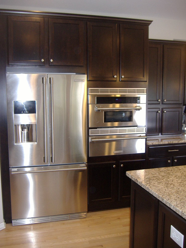 Transitional u-shaped eat-in kitchen photo in Indianapolis with an undermount sink, flat-panel cabinets, dark wood cabinets, granite countertops and stainless steel appliances