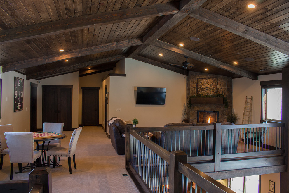 Inspiration for a mid-sized arts and crafts loft-style family room in Salt Lake City with beige walls, carpet, a standard fireplace, a stone fireplace surround and no tv.