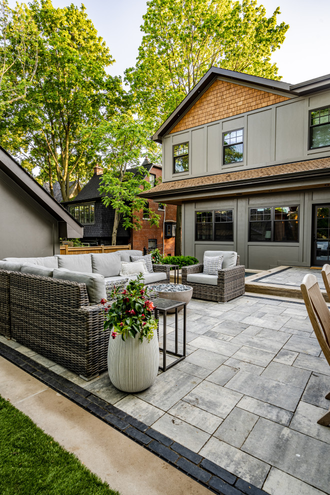 Photo of a mid-sized transitional partial sun front yard concrete paver and metal fence landscaping in Toronto for summer.
