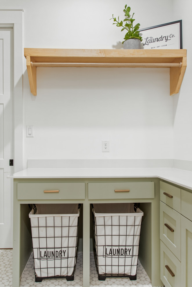 Design ideas for a mid-sized scandinavian l-shaped dedicated laundry room in Dallas with an undermount sink, shaker cabinets, green cabinets, quartz benchtops, white walls, porcelain floors, a side-by-side washer and dryer, multi-coloured floor and white benchtop.