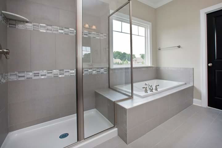 Corner bathtub - master gray tile and porcelain tile porcelain tile and gray floor corner bathtub idea with a hinged shower door