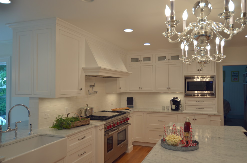 Eat-in kitchen - transitional u-shaped medium tone wood floor eat-in kitchen idea in Boston with a farmhouse sink, beaded inset cabinets, white cabinets, marble countertops, white backsplash, subway tile backsplash, stainless steel appliances and an island