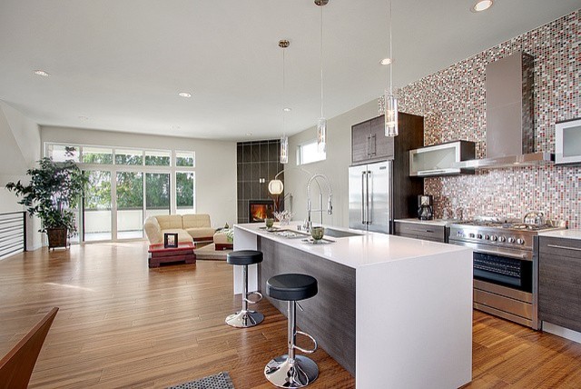 Photo of a mid-sized modern l-shaped open plan kitchen in Seattle with an undermount sink, flat-panel cabinets, dark wood cabinets, multi-coloured splashback, ceramic splashback, stainless steel appliances, medium hardwood floors and with island.
