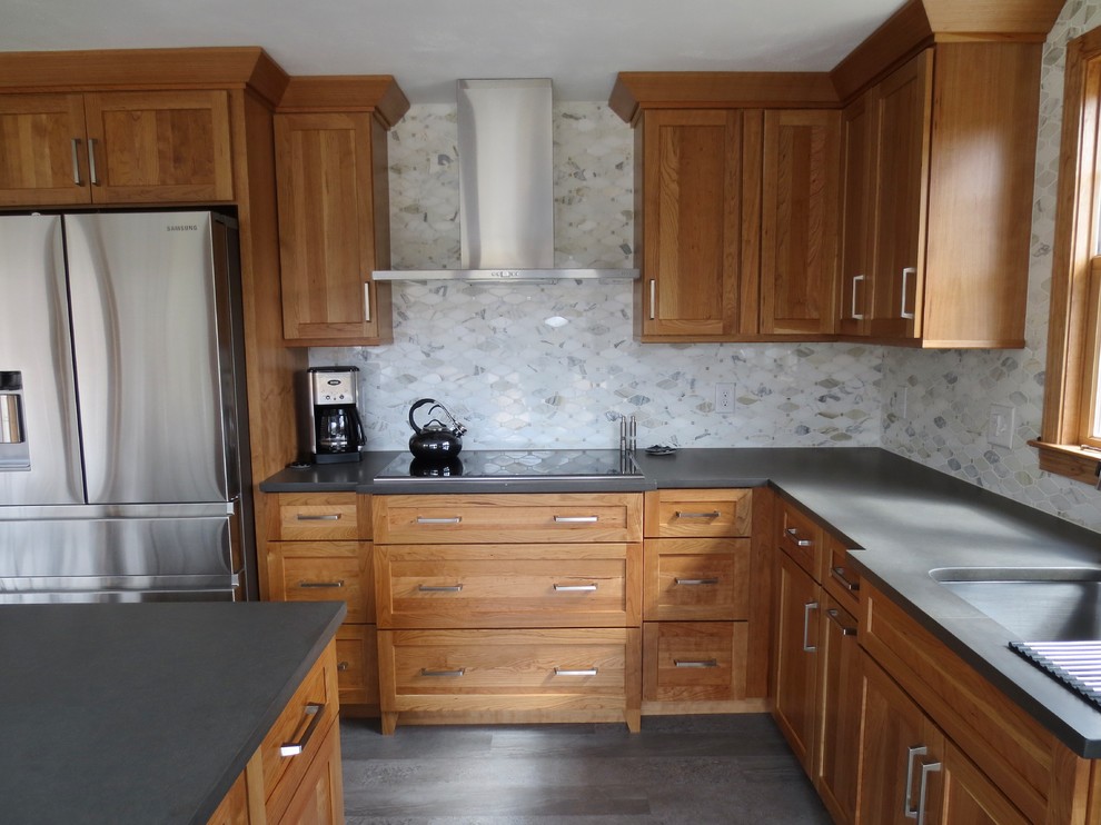 Mid-sized traditional l-shaped eat-in kitchen in Boston with an undermount sink, shaker cabinets, medium wood cabinets, quartz benchtops, white splashback, marble splashback, stainless steel appliances, vinyl floors, with island, grey floor and grey benchtop.