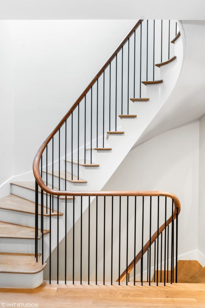 Staircase - transitional curved wood railing staircase idea in Chicago