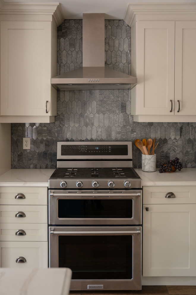 Mid-sized transitional l-shaped dark wood floor and brown floor eat-in kitchen photo in Toronto with an undermount sink, shaker cabinets, white cabinets, quartz countertops, gray backsplash, marble backsplash, stainless steel appliances, an island and multicolored countertops