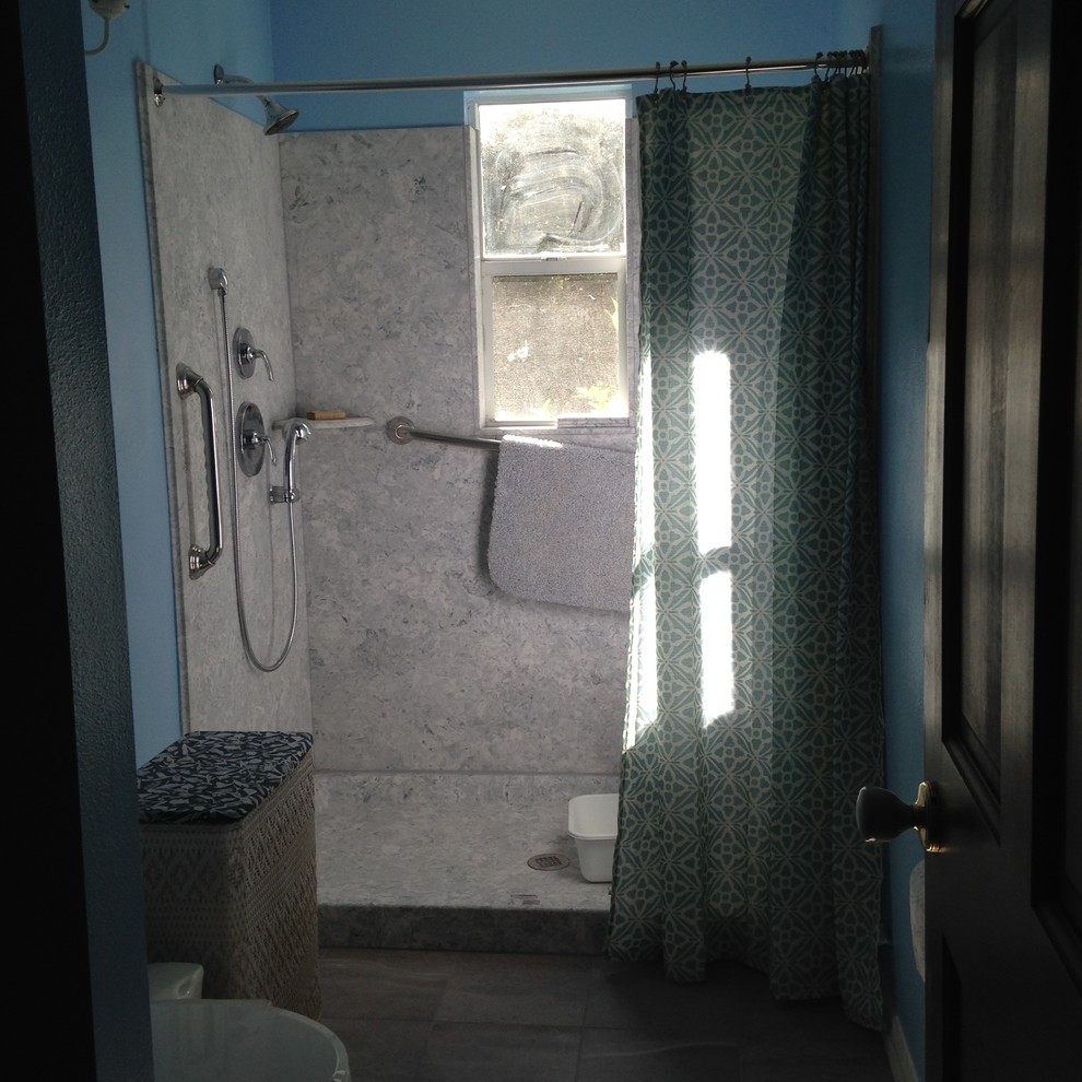 Design ideas for a small country bathroom in Orlando with raised-panel cabinets, white cabinets, an alcove shower, a two-piece toilet, gray tile, porcelain tile, blue walls, pebble tile floors, an integrated sink and marble benchtops.