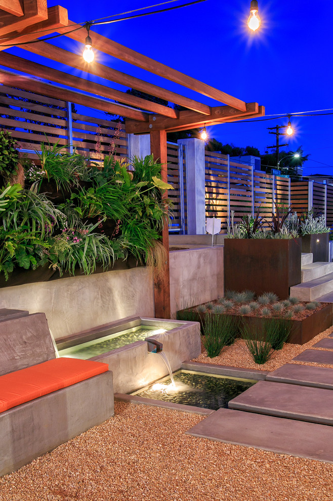 This is an example of a contemporary courtyard full sun garden in San Diego with a water feature and gravel.